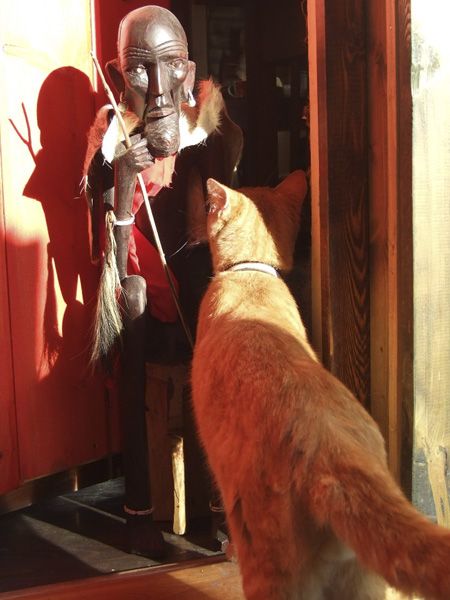 Русский рыжий кот по имени Герц и африканская статуэтка Проводник